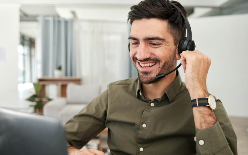 man-remote-work-and-virtual-assistant-with-headphones-at-laptop-for-video-call-voip-communication