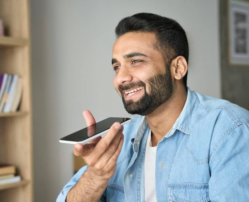 Young-Indian-Man-Speaking-To-Voice-Assistant-Using-Smartphone-.Jpg